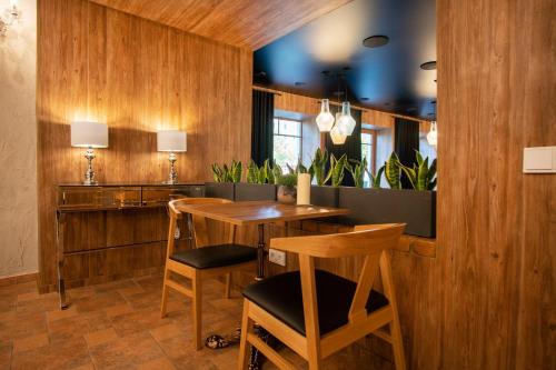 a dining room with wooden walls and a table and chairs at Hotel Tomas in Šiauliai