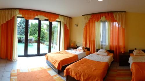 a bedroom with three beds and a large window at Dom Gościnny Przedmieście in Kielce