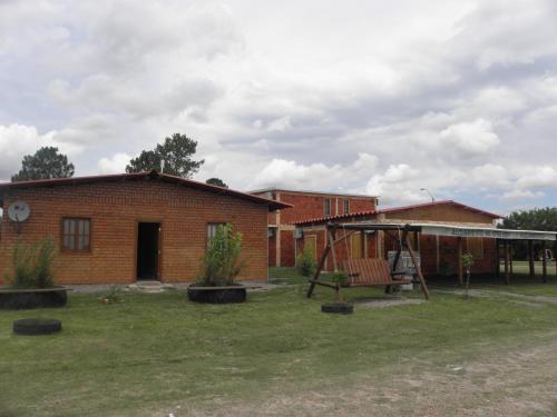 una casa de ladrillo con parque infantil en el patio en Alojamiento Termal Guaviyú, en Termas de Guaviyú