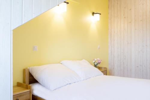 a bedroom with a white bed with two pillows at Dworek Zyskowskiego in Danowskie