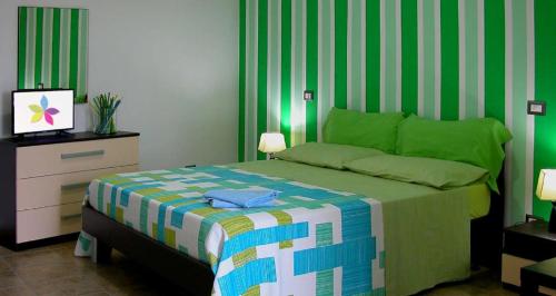 Valguarnera CaropepeにあるBed House Floristellaの緑と白のストライプのベッド1台が備わるベッドルーム1室
