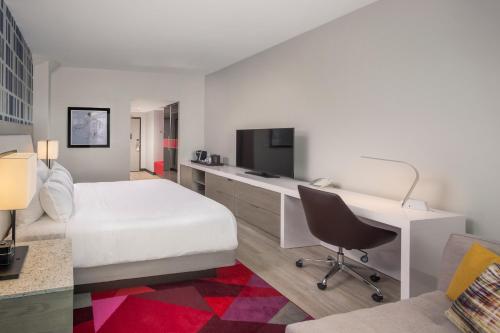 a bedroom with a bed and a desk with a computer at The Summit Hotel in Cincinnati