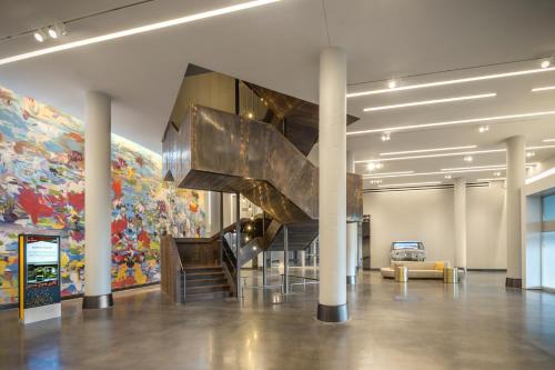 a staircase in a lobby with a mural at The Summit Hotel in Cincinnati