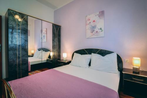 - une chambre avec un grand lit et une couverture rose dans l'établissement Apartment Lana, à Senj