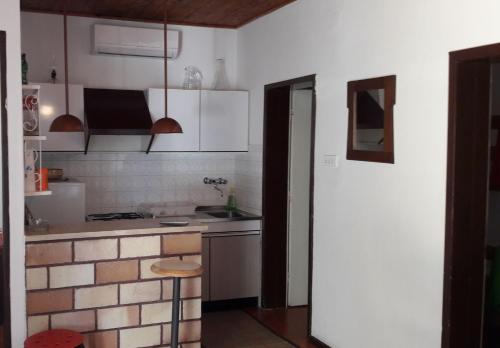 a kitchen with white cabinets and a counter top at Kuća za odmor Lucija in Ivan Dolac