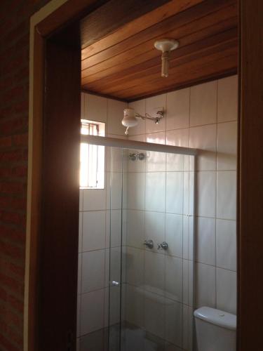 a bathroom with a shower and a toilet and a window at Aconchego do Guara , próximo ao centro médico, Boldrini, Unicamp, Laboratório CNPEN, Universidades e Hospital Sobrapar in Barão de Geraldo