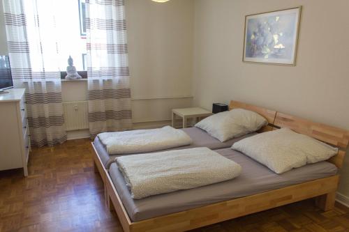 a bedroom with a bed with two pillows on it at Pension Wesertal in Porta Westfalica