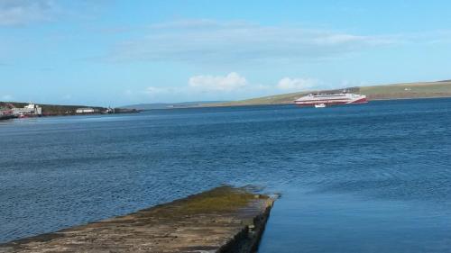 a boat in the middle of a large body of water at 2 The Noust Self Catering in Saint Margarets Hope