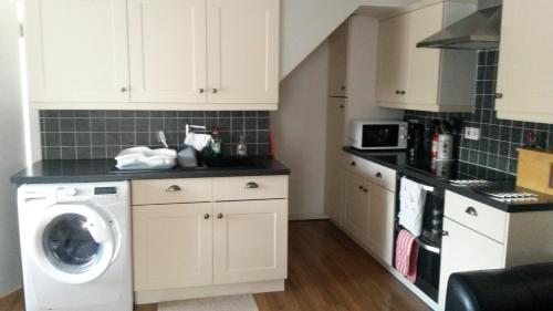 a kitchen with a washer and a washing machine at 2 The Noust Self Catering in Saint Margarets Hope