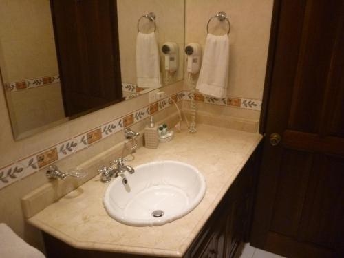 a bathroom with a white sink and a mirror at Hotel Casa La Fe in Cartagena de Indias