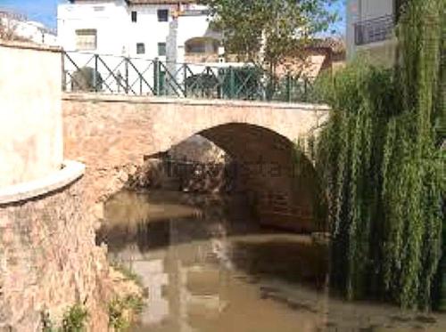 Puente de Génave的住宿－Apartamentos Azahar，一条有隧道的河上的石桥