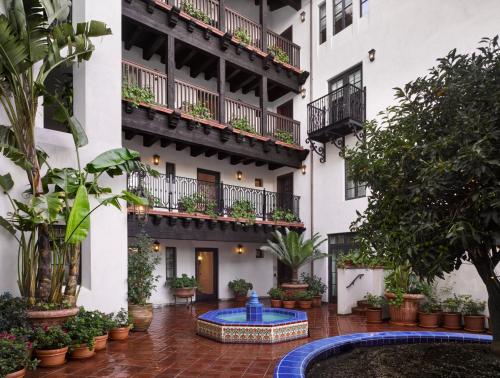 an apartment building with a courtyard with a fountain at Plaza la Reina in Los Angeles