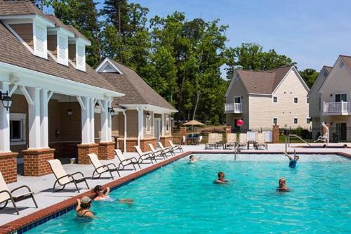 a group of people swimming in a swimming pool at King's Creek Resort by Endless Resorts in Williamsburg