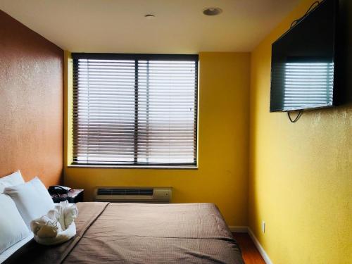 a bedroom with a bed and a window at The Vue Express @ 39th Street in Brooklyn