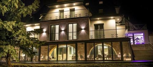 a large white building with lights on it at night at NovaWisła Resort & SPA in Wisła