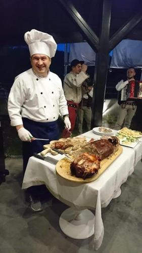 a chef is standing next to a table with meat at NovaWisła Resort & SPA in Wisła