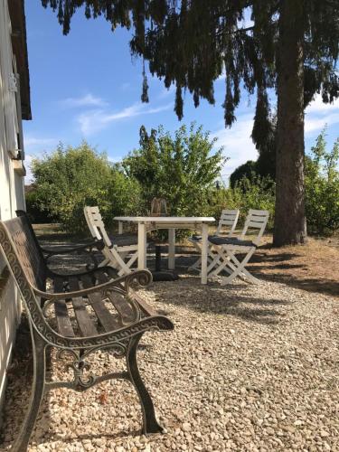 a picnic table and two chairs and a table and bench at Le Gîte de Saint Phal in Saint-Phal