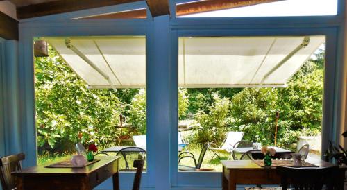 a patio with a table and chairs and a window at Locanda la Casetta in Angera
