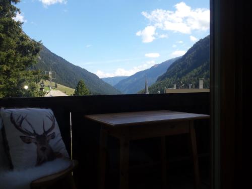 a table on a balcony with a view of mountains at Pension Alpenrose in Sankt Sigmund im Sellrain