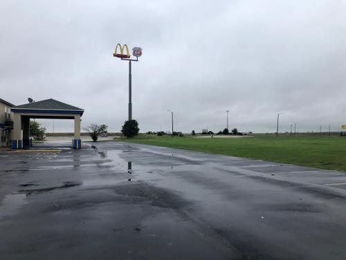 an empty parking lot with a street light and a gas station at Super 8 by Wyndham Chenoa in Chenoa