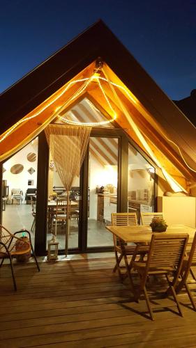 un patio avec une table et des chaises sur une terrasse dans l'établissement Gite La Fixoune, à Voegtlinshoffen