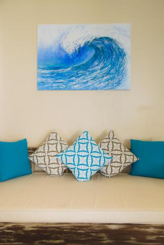 a couch with pillows sitting under a painting at The Zubeida Boutique Resort in Diani Beach