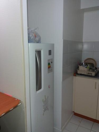 a white refrigerator in a kitchen next to a counter at Depto a pasos de Metro Irarrazaval in Santiago