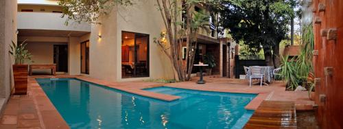 a swimming pool in front of a house at La Morada Posada Boutique in Asuncion