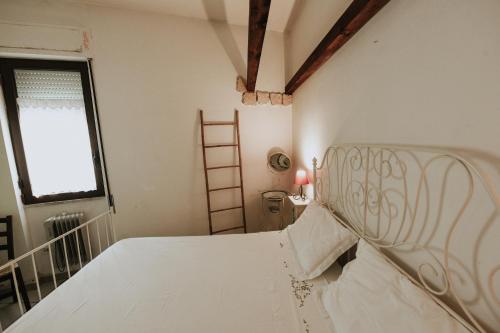 a white bed in a room with a window at antonella home in Brindisi