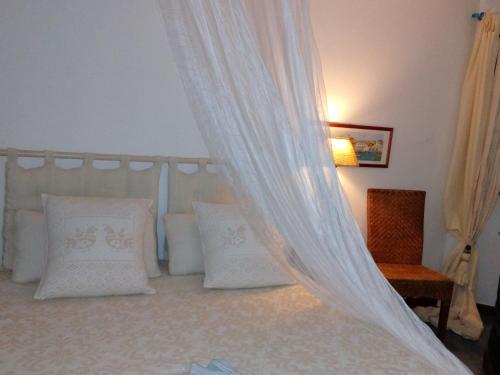 a bedroom with a canopy bed with white pillows at Il Rifugio del Conte in Torre Dei Corsari