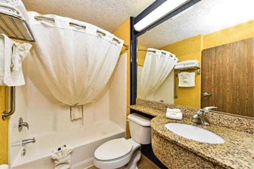 a bathroom with a toilet, sink, and shower at Microtel Inn & Suites by Wyndham New Braunfels I-35 in New Braunfels