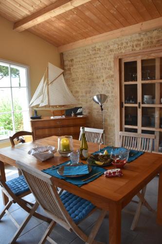 - une table en bois dans un salon avec un bateau sur un piano dans l'établissement Villa Blanche, à Loix