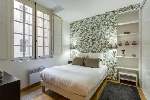 ein Schlafzimmer mit einem Bett mit einer grünen und weißen Wand in der Unterkunft Bordeaux Bouquiere in Bordeaux