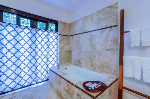 a bathroom with a bath tub and a window at Makara Rio Suite / Ground Floor in Uvita