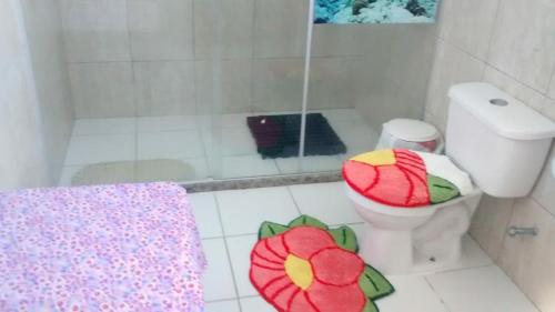 a white bathroom with a toilet and a shower at Pousadinha Mangabeiras Familia e Grupos in Guriri