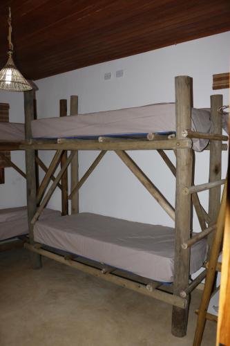 a wooden bunk bed in a room with a ceiling at Casa do Capão in Vale do Capao