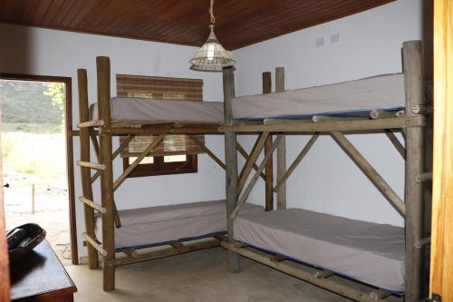 two bunk beds in a room with a lamp at Casa do Capão in Vale do Capao