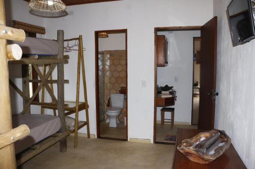 a room with bunk beds and a bathroom with a toilet at Casa do Capão in Vale do Capao