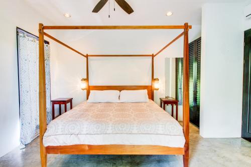 a bedroom with a four poster bed and two tables at Makara Suite Penthouse in Uvita