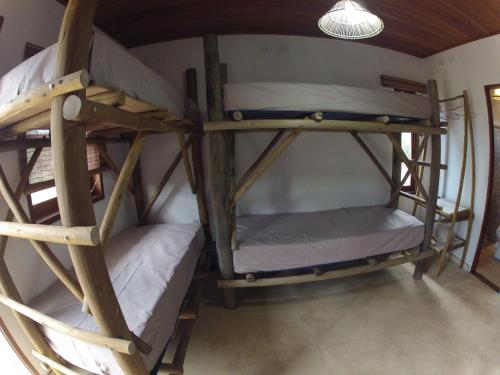 two bunk beds in a room with a lamp at Casa do Capão in Vale do Capao