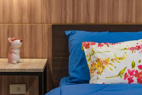 a bed with a pillow and a vase on a table at Penyos Residence in Bangkok