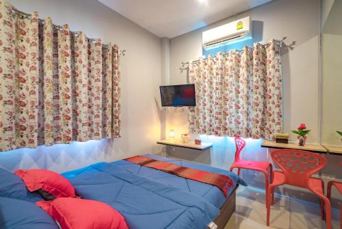 a bedroom with a blue bed and a red chair at Penyos Residence in Bangkok