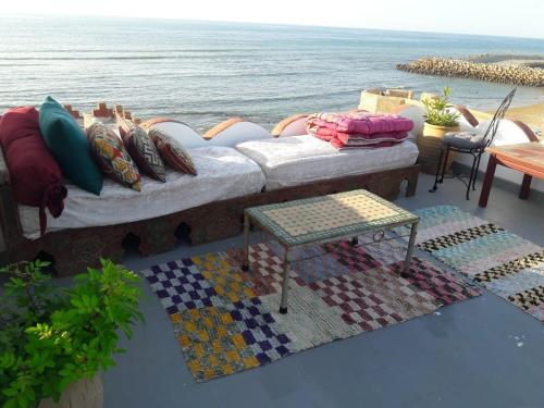 a couch sitting on a balcony overlooking the ocean at The Jewel of the Northern Moroccan Atlantic in Asilah in Asilah