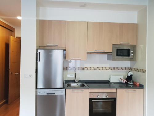 a kitchen with a stainless steel refrigerator and a sink at Loft Velázquez Moreno 35 in Vigo