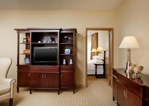 a living room with a television in a room at Anaheim Majestic Garden Hotel in Anaheim