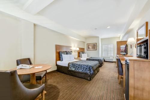 Habitación de hotel con cama y mesa en Anaheim Desert Inn & Suites, en Anaheim