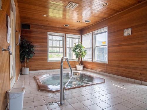 a bathroom with a hot tub in a room with wooden walls at The Ranchland Inn Kamloops in Kamloops