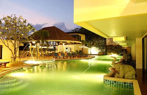 a swimming pool in a resort with a swimming pool at Palmyra Patong Resort Phuket - SHA Extra Plus in Patong Beach