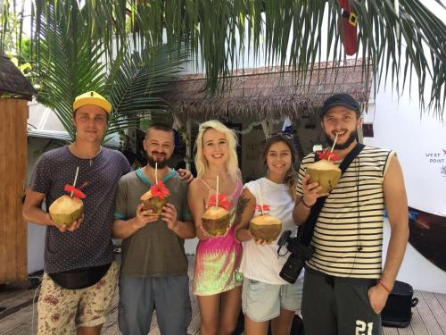 a group of people posing for a picture with drinks at Dive Villa Thoddoo in Thoddoo