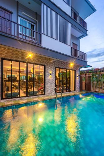 a swimming pool in front of a house at Penyos Residence in Bangkok